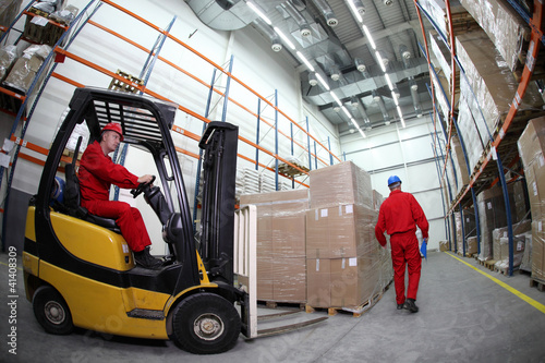 Photo: two workers work in storehouse two workers work in storehouse