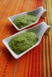 Green broad beans cream in white china dish on orange background Green broad beans cream in white china dish on orange background