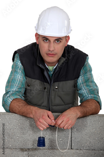 Photo: A mason with a plumb-bob. A mason with a plumb-bob.