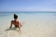 Brunette sat on a beach looking towards the horizon Brunette sat on a beach looking towards the horizon