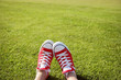 Feet in sneakers in green grass