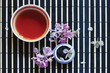 Cup of tea, jar of tea leaves and cherry blossoms with lilac