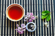 Cup of tea, jar of tea leaves and cherry blossoms and lilac