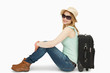 Photo: Woman wearing sunglasses while sitting near a suitcase Woman wearing sunglasses while sitting near a suitcase