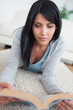 Woman reading a book while lying on the floor