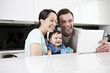 A couple and their baby son looking at a digital tablet