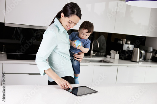 Foto: A mother and her baby son looking at a digital tablet A mother and her baby son looking at a digital tablet
