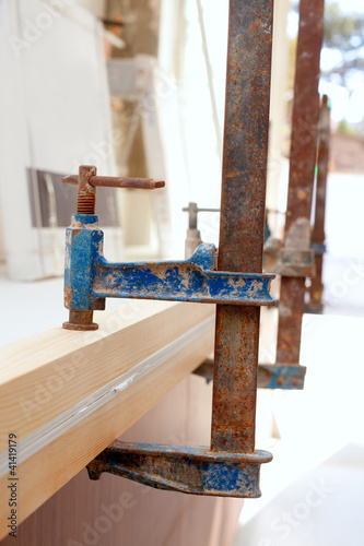 Photo: Carpenter screw clamp tool pressing wood slats Carpenter screw clamp tool pressing wood slats