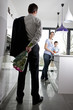 A man returning home to his family, holding a bunch of roses