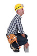 Tradesman struggling to lift a block