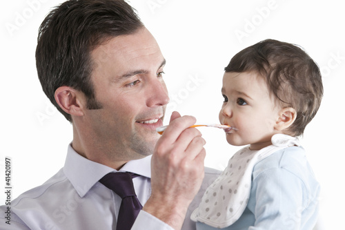 Photo: A father feeding his baby son A father feeding his baby son