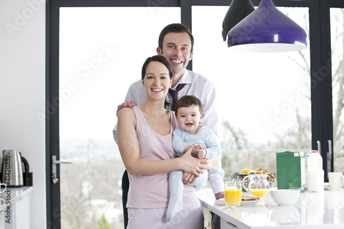 Photo: A couple and their baby son in the kitchen at breakfast time A couple and their baby son in the kitchen at breakfast time