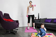 A young mother exercising at home with her baby