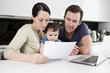A couple and their baby son looking at their household finances