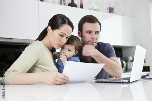 Photo: A couple and their baby son looking at their household finances A couple and their baby son looking at their household finances