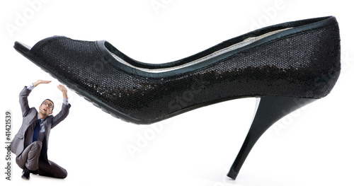 Photo: Woman domination concept with shoes and man Woman domination concept with shoes and man