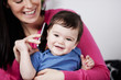 A mother and her baby son listening on a mobile phone