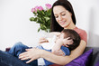 A mother feeding her baby son a bottle of milk