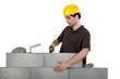 Mason knocking bricks into place with hammer
