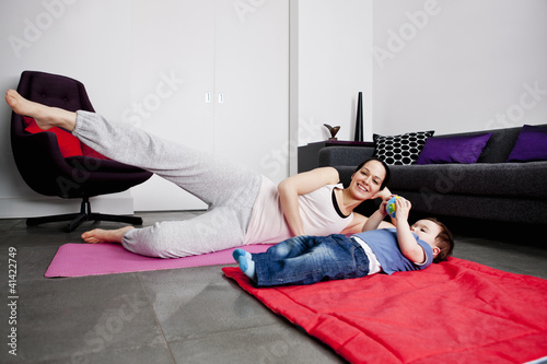 Photo: A mother and her baby son exercising at home A mother and her baby son exercising at home