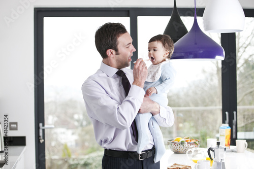 Foto: A father feeding his baby son breakfast A father feeding his baby son breakfast