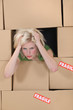 Stress blond woman amongst boxes