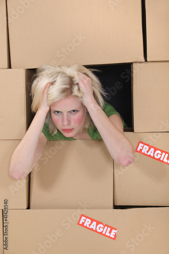 Photo: Stress blond woman amongst boxes Stress blond woman amongst boxes