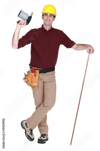 Photo: Blow torch and copper pipe being held by plumber Blow torch and copper pipe being held by plumber