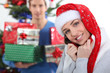 Couple sat by Christmas tree with presents