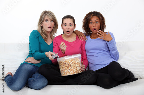 Photo: Three women eating popcorn whilst watching film Three women eating popcorn whilst watching film