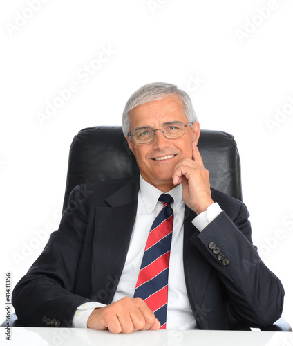 Photo: Mature Businessman Seated at Desk Mature Businessman Seated at Desk