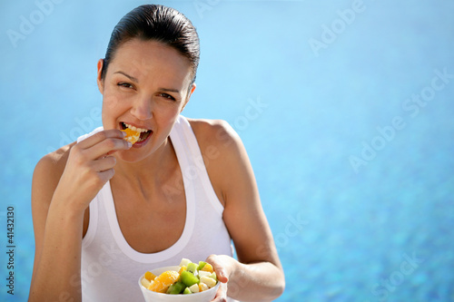 Photo: Woman eating fruit in a swimming pool Woman eating fruit in a swimming pool