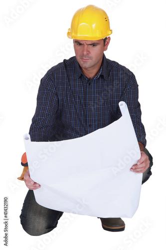 Photo: Angry tradesman looking at a technical drawing Angry tradesman looking at a technical drawing