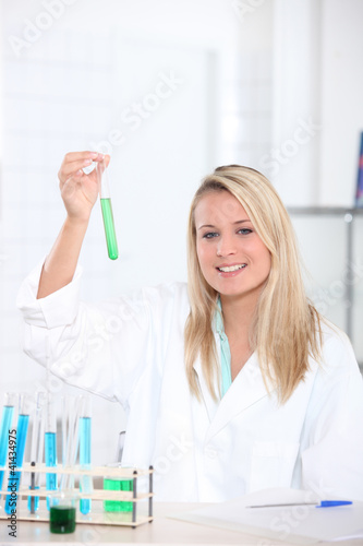 Photo: female biologist in laboratory holding test tube female biologist in laboratory holding test tube