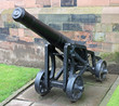 A Vintage Heavy Cannon Outside a Castle Wall.