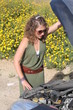 Curly blonde woman having troubles with her car