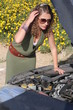 Curly blonde woman having troubles with her car