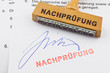 Holzstempel auf Dokument: Nachprüfung