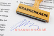Holzstempel auf Dokument: Krankenkasse
