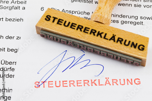 Foto: Holzstempel auf Dokument: Steuererklärung Holzstempel auf Dokument: Steuererklärung