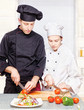 Photo: Senior chef teaches young chef to properly cut Senior chef teaches young chef to properly cut