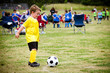 Young child boy playing soccer during organized league game Young child boy playing soccer during organized league game