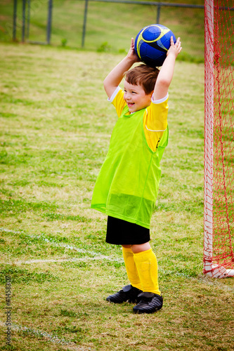 Photo: Young child boy playing soccer during organized league game Young child boy playing soccer during organized league game