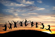 silhouetted teenagers jump on hill in sunset silhouetted teenagers jump on hill in sunset