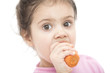 Little girl eating carrot over the white background Little girl eating carrot over the white background