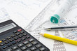 Calculator and pencil on the paper with financial graph's