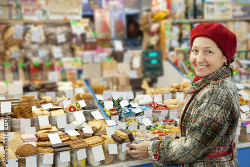 Photo: Mature woman chooses sweets Mature woman chooses sweets