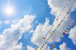 Photo: Blue sky with multi colored party flags hanging Blue sky with multi colored party flags hanging