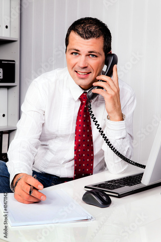Foto: Geschäftsmann im Büro mit Telefon Geschäftsmann im Büro mit Telefon
