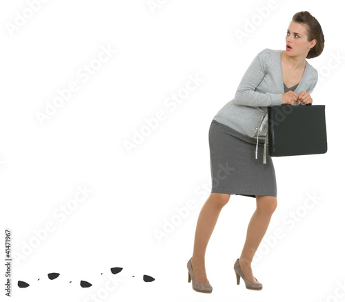 Photo: Sneaking business woman with briefcase leaving trace Sneaking business woman with briefcase leaving trace